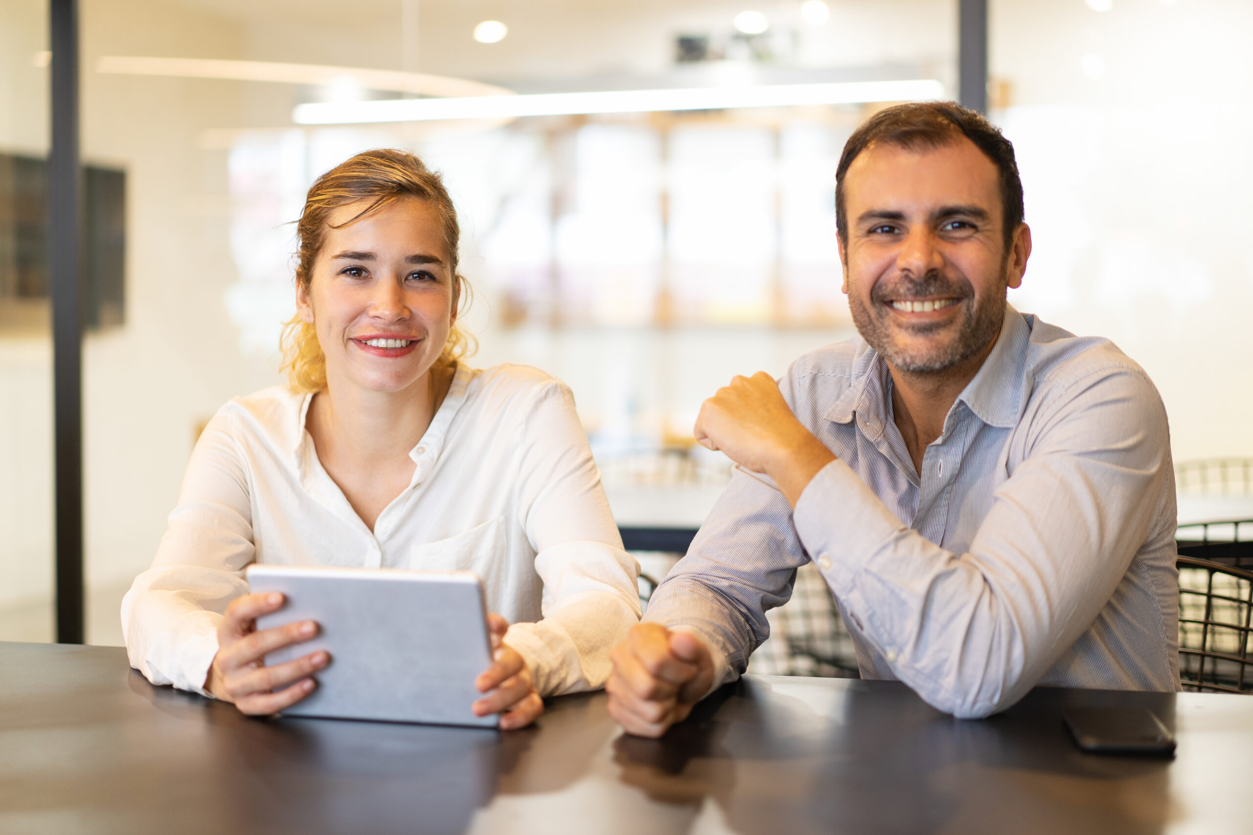 portrait of happy colleagues sitting at cafe during break